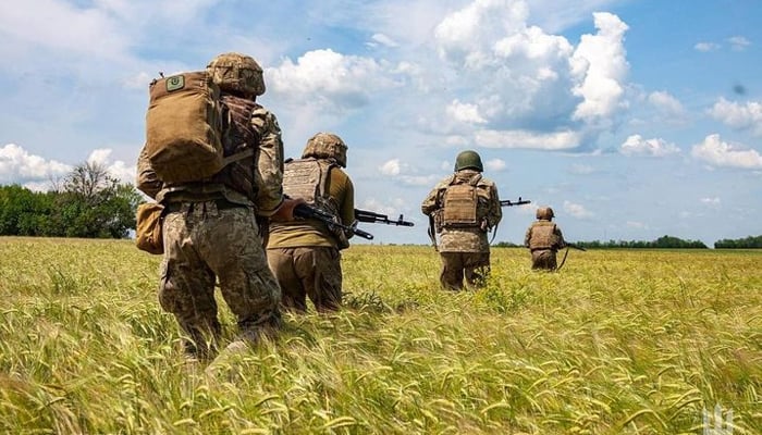 Ukrainian troops can be seen walking on a battlefield in Ukraine in this picture released on July 26, 2023. — Instagram/zelenskiy_official