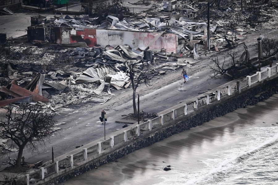 An aerial image taken on August 10, 2023, shows a person walking past buildings burned to the ground in Lahaina in western Maui, Hawaii. — AFP/File