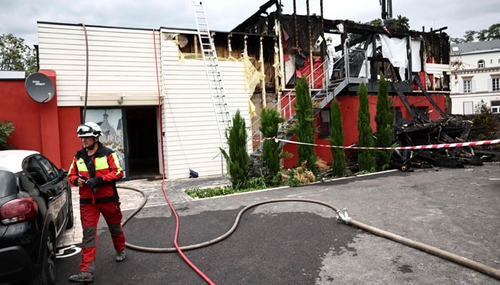 A firefighter is at work at the place where a fire erupted at a holiday home for disabled people in Wintzenheim, eastern France, on August 9, 2023. — AFP