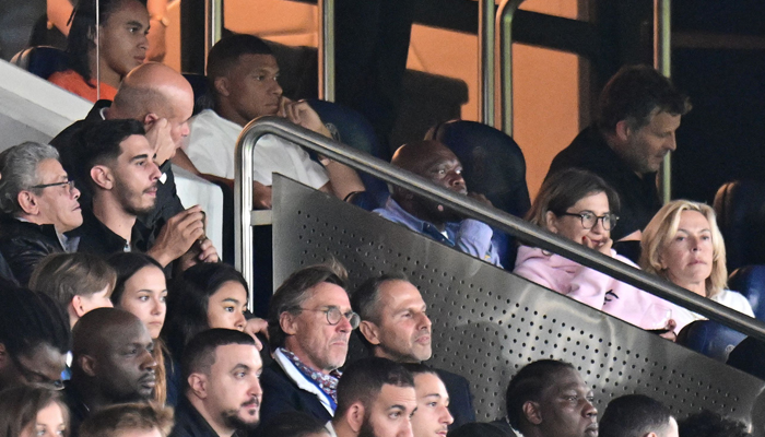 Paris Saint-Germains French forward Kylian Mbappe attends from the stand the French L1 football match between PSG and Lorient at the Parc des Princes Stadium in Paris on August 12, 2023. — AFP
