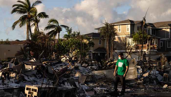 A Mercy Worldwide volunteer makes a damage assessment of a charred apartment complex in the aftermath of a wildfire in Lahaina, western Maui, Hawaii on August 12, 2023. — AFP