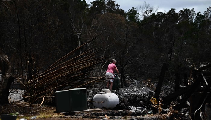 A caretaker hangs a no trespassing sign at the site of a home destroyed by the Maui wildfires in Kula, Hawaii on August 13, 2023. — AFP