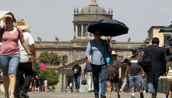 This representational picture shows tourists and locals walking in scorching heat in Mexico on June 12, 2023. — AFP