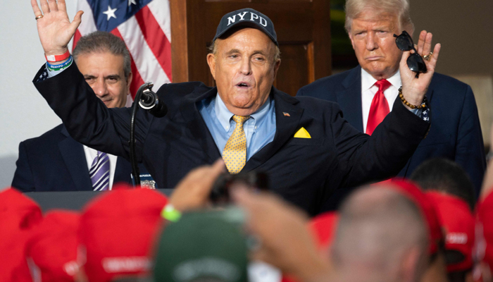 US President Donald Trump (R) listens as his personal lawyer Rudy Giuliani speaks to the City of New York Police Benevolent Association at the Trump National Golf Club in Bedminster, NJ, on August 14, 2020. — AFP