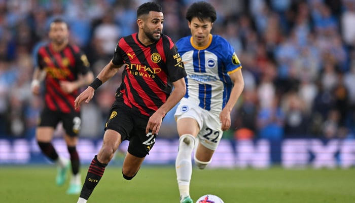 Manchester Citys Algerian midfielder Riyad Mahrez (L) controls the ball past Brightons Japanese midfielder Kaoru Mitoma during the English Premier League football match on May 24, 2023. — AFP