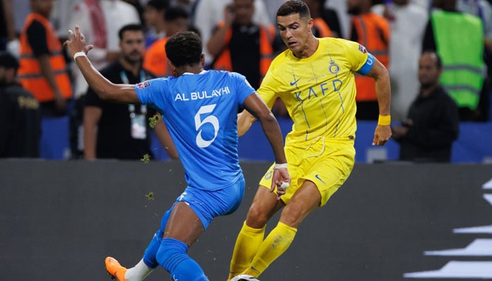 Hilals Saudi defender Ali al-Bulaihi (L) fights for the ball with Nassrs Portuguese forward Cristiano Ronaldo during the 2023 Arab Club Champions Cup final football match at the King Fahd Stadium in Taif on August 12, 2023. — AFP