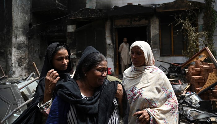 Pakistani Christian Perveen Bibi (centre) weeps outside the torched Saint John Church in Jaranwala on the outskirts of Faisalabad on August 17, 2023, a day after an attack over blasphemy allegations. — AFP