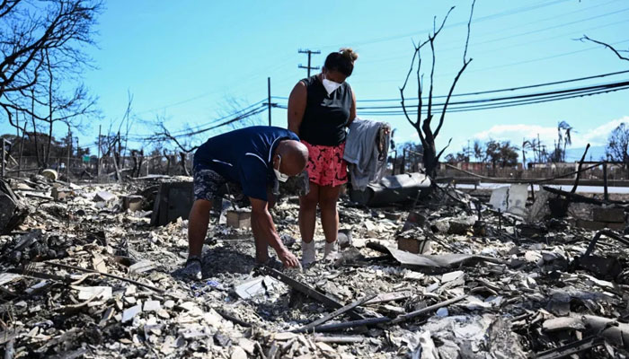A man and woman look for belongings through the ashes of their familys home on August 11, 2023, in the aftermath of a wildfire in Lahaina, in western Maui, Hawaii. — AFP/File