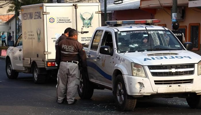 Police officers investigating an attack on a patrol car in Duran, Ecuador, on Nov 1, 2022. — AFP
