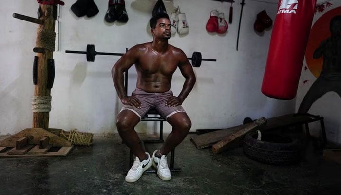 Cubas Ironman Lino Tomasen talks to his father (not pictured) during a training session in his home in Guanabo, Cuba, on August 11, 2023.—Reuters