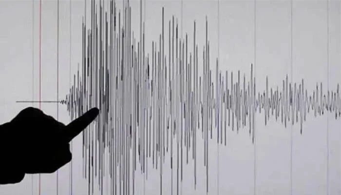 A person pointing toward the intensity of an earthquake shown on a Richter scale. — Reuters/File