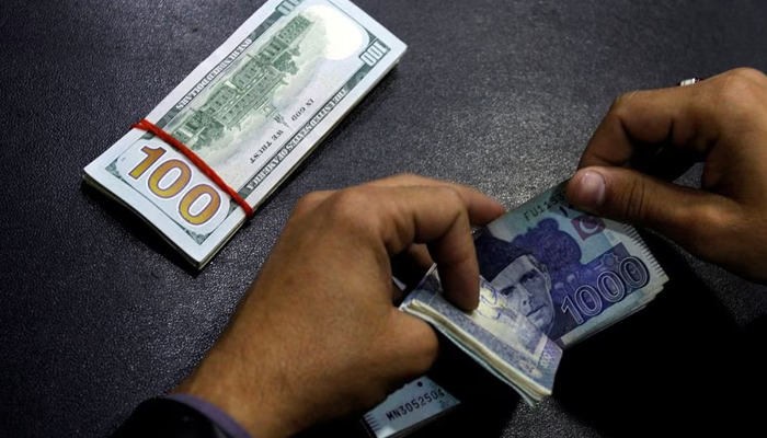 A currency trader counts Pakistani Rupee notes as he prepares an exchange of US dollars in Islamabad, Pakistan December 11, 2017. — Reuters