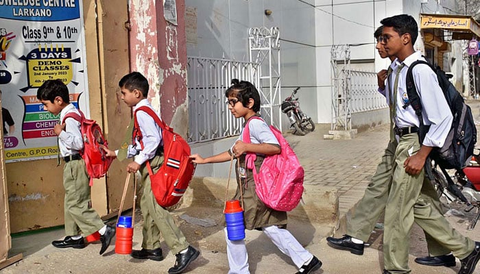Students are going to their school for the first day after the summer vacation in Larkana. — APP/File