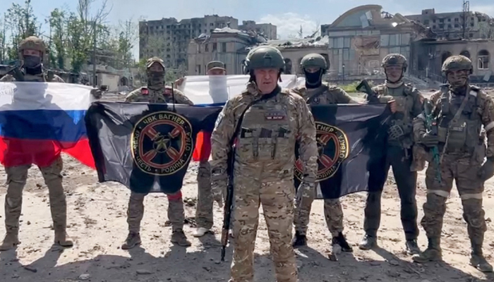 This grab on May 20, 2023, shows Yevgeny Prigozhin standing in front of a Russian national flag in front of his soldiers holding Wagner Groups flags in Bakhmut. — AFP