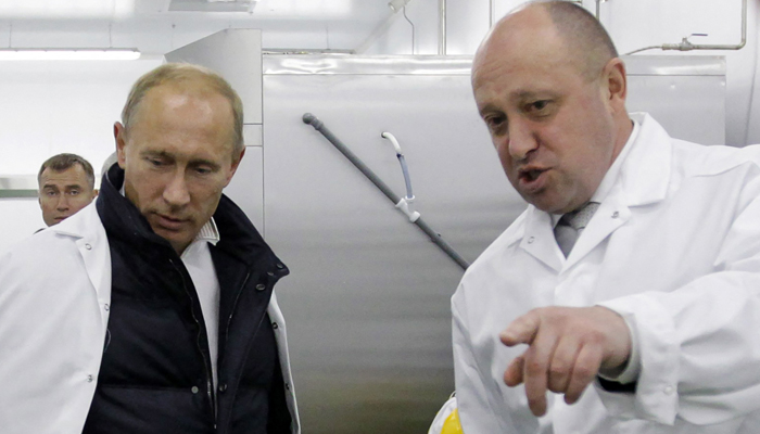 A businessman at that time Yevgeny Prigozhin (R) points out as he shows the then-Prime Minister Russia Vladimir Putin his school lunch factory outside Saint Petersburg on September 20, 2010. — AFP