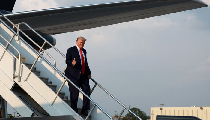 Former US President Donald Trump gives a thumbs up as he arrives at Atlanta Hartsfield-Jackson International Airport on August 24, 2023, in Atlanta, Georgia. — AFP