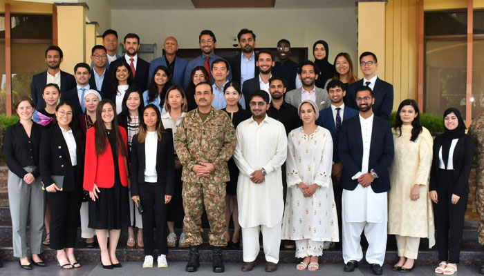 Chief of Army Staff (COAS) General Syed Asim Munir poses for a group photo with students from Harvard University at the General Headquarters (GHQ) in Rawalpindi on August 25, 2023. — ISPR