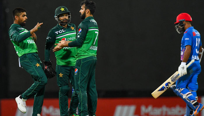 Pakistan´s captain Babar Azam (L) celebrates with teammates after the dismissal of Afghanistan´s Hashmatullah Shahidi (R) during the third and final one-day international (ODI) cricket match between Pakistan and Afghanistan at the R. Premadasa Stadium in Colombo on August 26, 2023. — AFP