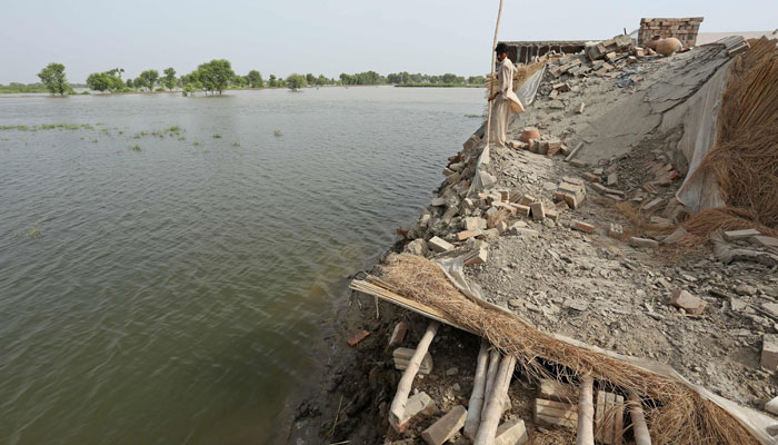 A boy stands on the wreckage of his damaged house at the flood affected area of Bahawalnagar in Punjab province on August 26, 2023. — AFP