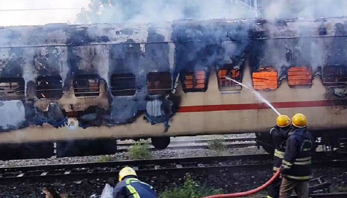 Firefighters try to extinguish a fire which broke out in a train coach parked at Madurai. — AFP