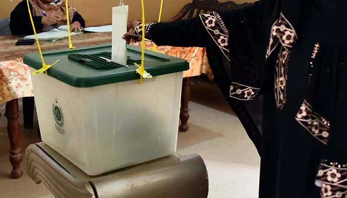 A woman casts her vote at a polling station during by-elections in Karachi on October 16, 2022. — PPI