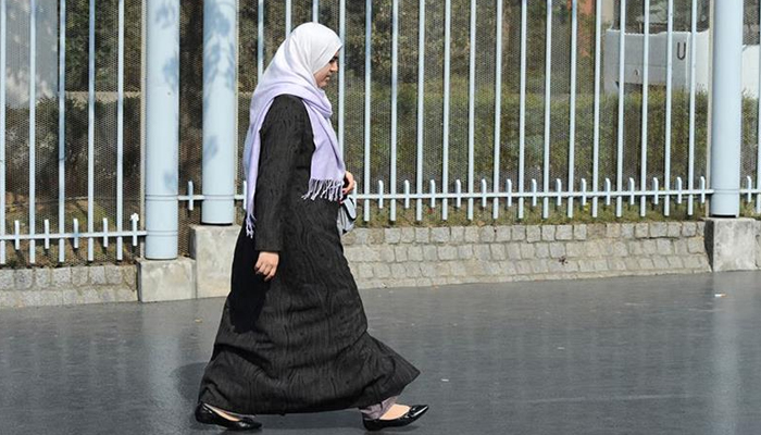 A woman wearing a hijab, and abaya walks in a street in Nanterre, outside Paris. — AFP/File