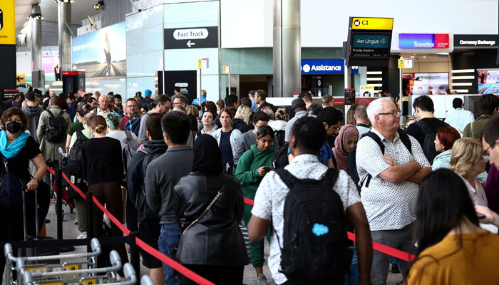 Passengers queue inside the departures terminal at a UK airport. — Reuters