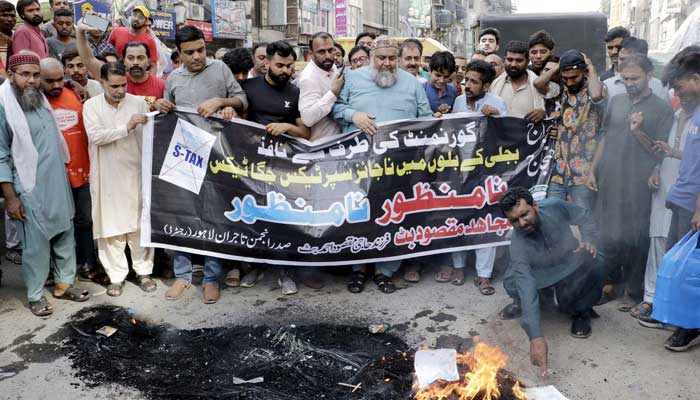 Traders in Lahore burn electricity bills and tyre to protest against inflation and massive tariff hike on August 29, 2023. — PPI