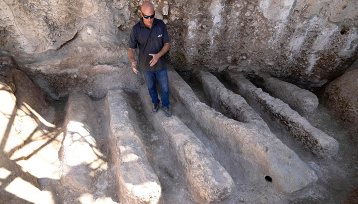 An Israel Antiquities Authority archaeologist shows an ancient channel installation discovered in the City of David National Park in Jerusalem, on August 30, 2023.—AFP
