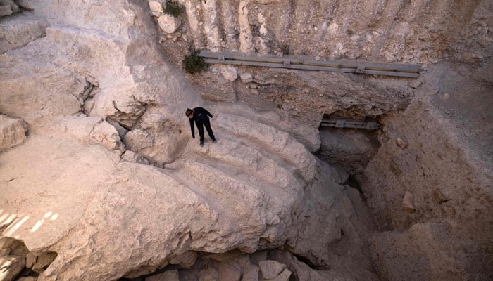 Israel Antiquities Authority archaeologist Yiftah Shalev shows an ancient channel installation discovered in the City of David National Park in Jerusalem, on August 30, 2023.—AFP