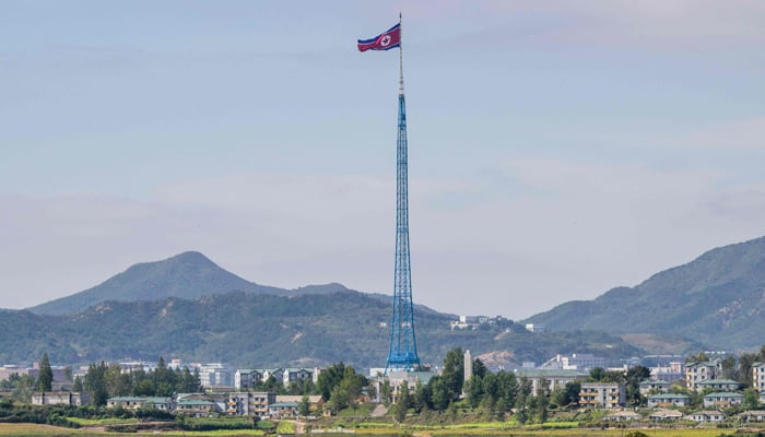 This picture shows a North Korean flag fluttering in the wind at the village of Gijungdong in North Korea on October 4, 2022, near the truce village of Panmunjom inside the Demilitarized Zone (DMZ). — AFP