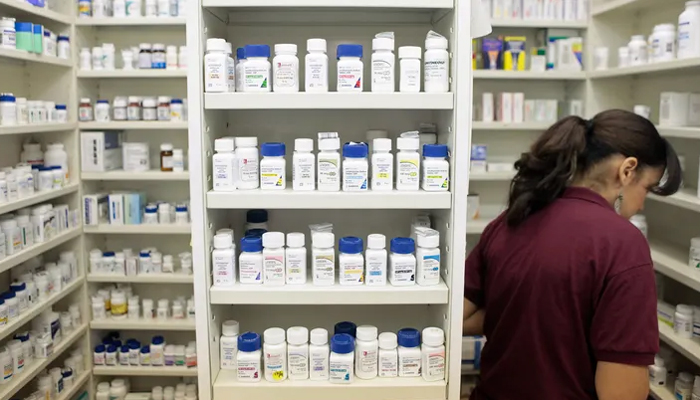 A pharmacy employee looks for medication as she works to fill a prescription while working at a pharmacy in New York. — Reuters/File