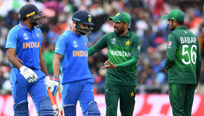 Mohammad Amir (2R) and teammate Babar Azam (R) speak with Indias captain Virat Kohli (C) and Indias Vijay Shankar (L) as they walk back to the pavilion as rain stops play during the 2019 Cricket World Cup group stage match between India and Pakistan at Old Trafford in Manchester, northwest England. — AFP