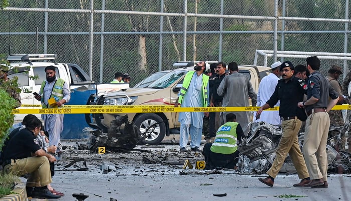 Security personnel gather at the site of the bomb blast in Hayatabad area of Peshawar on July 18, 2023. — AFP