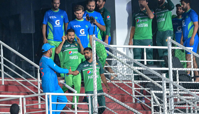 Indias captain Rohit Sharma (L) shakes hands with Pakistans captain Babar Azam (R, bottom) at the end of the Asia Cup 2023 ODI match between India and Pakistan at the Pallekele International Cricket Stadium in Kandy on September 2, 2023. — AFP