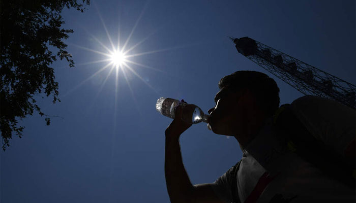A man drinks water during a hot summer day. — AFP/File