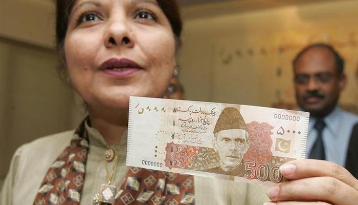 Caretaker Finance Shamshad Akhtar holds a 5,000 rupees ($83) currency note during a news briefing in Karachi May 26, 2006. — Reuters