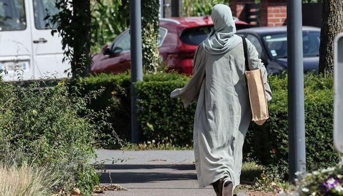 A woman wearing an abaya walks through the streets of Lille, northern France. — AFP/File