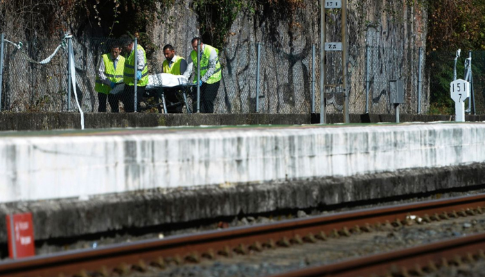A body is being transported by healthcare personnel after a train crash in Spain. — AFP/File
