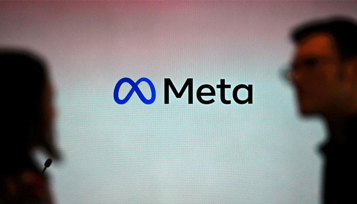 Visitors stand in front of a Meta logo during a launch event at the corporate offices of Meta in Berlin on June 6, 2023. — AFP/File
