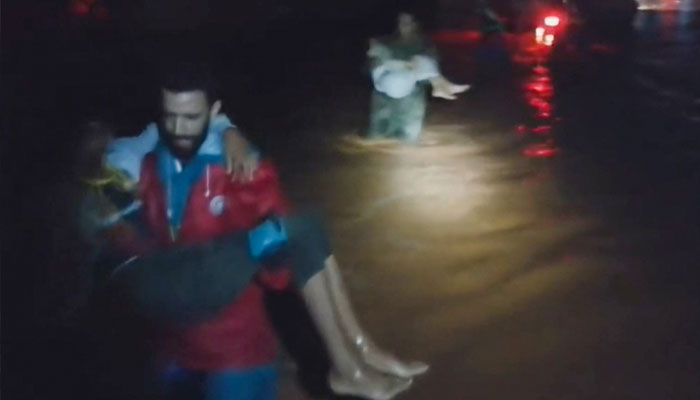 A grab from a video released by the Libyan Red Crescent on September 11, 2023, reportedly shows members of their team rescuing people from floods at an undefined location in eastern Libya.—AFP