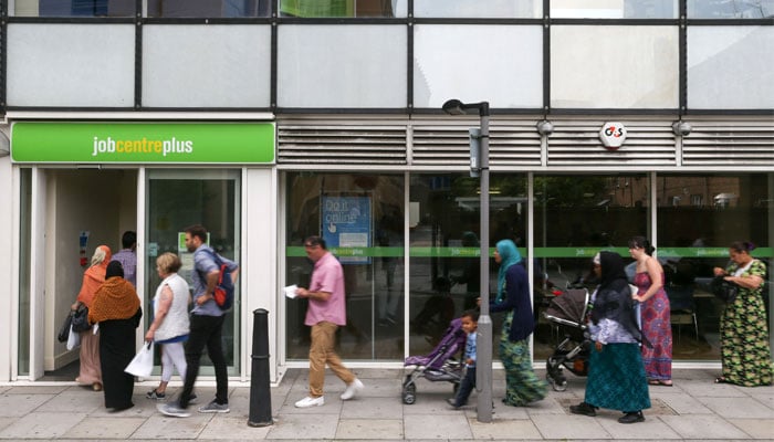 People queue to enter a job centre in east London on July 20, 2016. — AFP/File