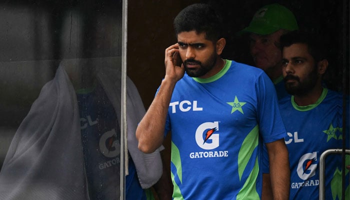 Pakistans captain Babar Azam (2L) waits near a room as rain delays the Asia Cup 2023 super four one-day international (ODI) cricket match between India and Pakistan at the R. Premadasa Stadium in Colombo on September 11, 2023. — AFP