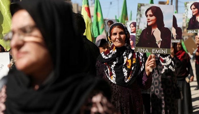 Women carry flags and pictures during a protest over the death of 22-year-old Kurdish woman Mahsa Amini in Iran, in the Kurdish-controlled city of Qamishli, northeastern Syria September 26, 2022.—Reuters