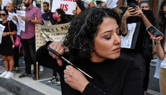 A woman cuts her hair during a protest against the Islamic regime of Iran and the death of Mahsa Amini in New York City, New York, US, September 27, 2022.—Reuters