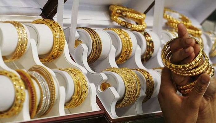 A customer wears gold bangles at a jewelry shop in this undated file photo. — Agencies