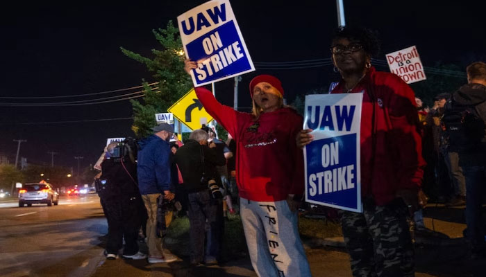 Members of the UAW (United Auto Workers) picket and hold signs outside of the UAW Local 900 headquarters across the street from the Ford Assembly Plant in Wayne, Michigan on September 15, 2023. AFP