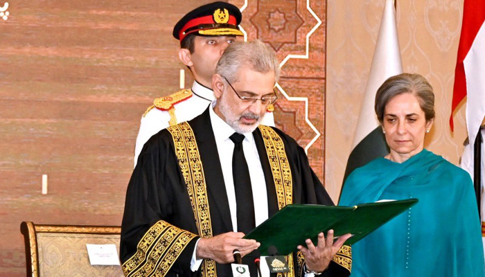 Chief Justice of Pakistan Qazi Faez Isa takes the oath of office with his wife Sarina Isa standing beside him at the President House on September 17, 2023. — President House