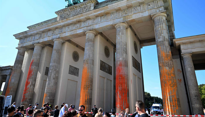 The columns of Berlin´s landmark the Brandenburg Gate are covered in orange paint on September 17, 2023 in Berlin.—AFP