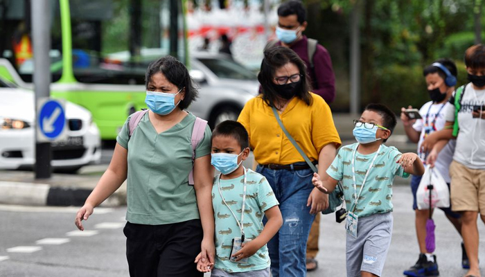 People wearing face masks cross a road amid the coronavirus disease (COVID-19) outbreak in Singapore. — Reuters/File
